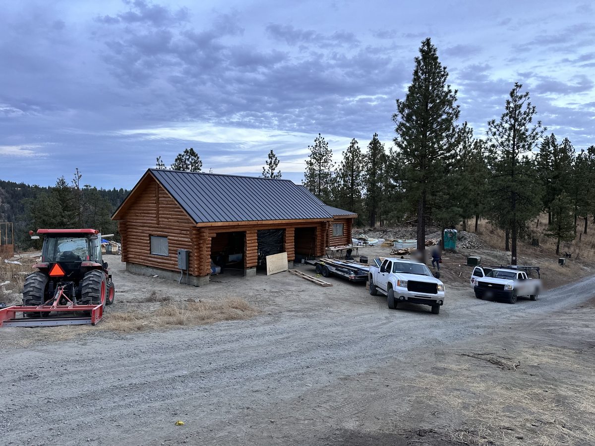 Our log shop and garage among the pines in the hills above Chelan at dusk